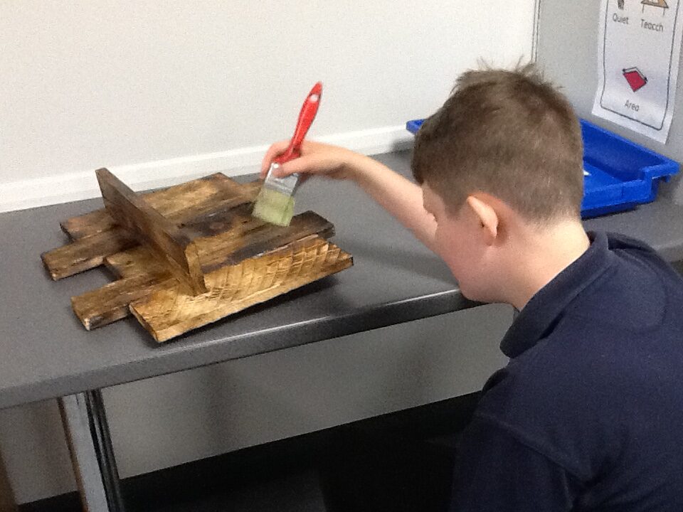 Pupil varnishing a shelf