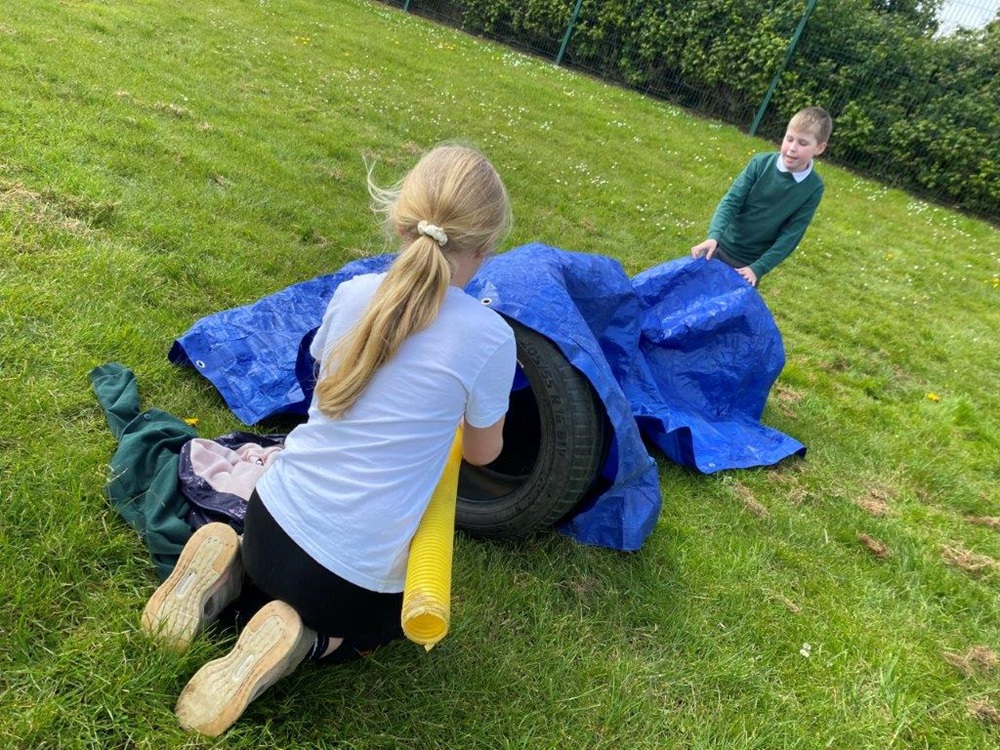 Pupils create a tunnel from tarpaulin and tyres