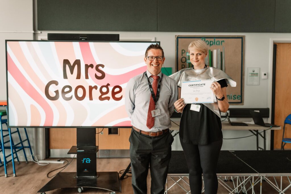 Paul Hill, Director of Primary Education, presents Mrs George with her certificate