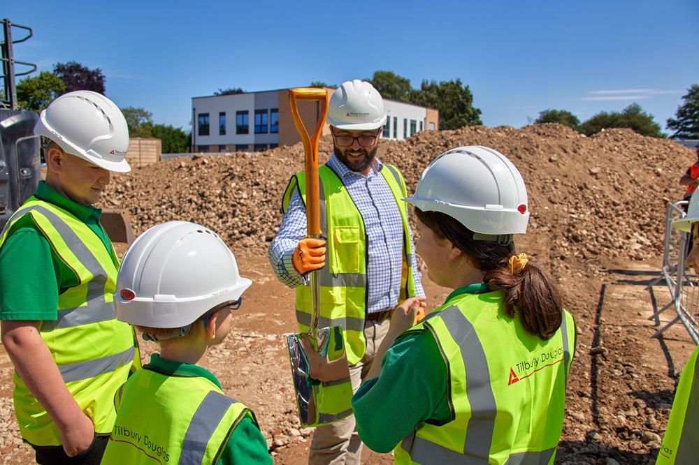 Site Manager hand pupils a spade