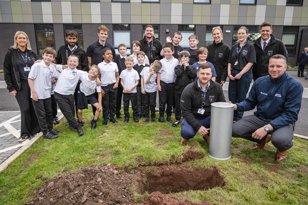 Teachers and pupils bury a time capsule